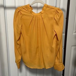 Yellow blouse with delicate buttons and pleats